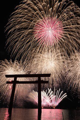 湖面に映える鳥居を背景にスターマインが夜空を染める