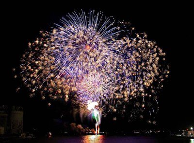 水面に映る華やかな花火が夜空を彩る