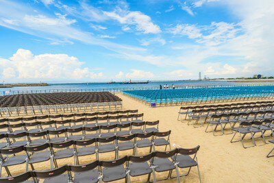 海を望む砂浜にずらりと並ぶパイプ椅子席