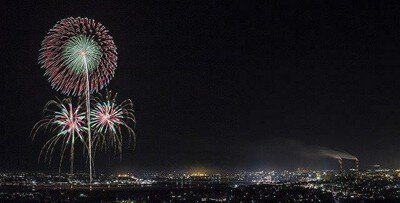 夜景とともに浮かぶ繊細な花火の輪