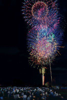 河川敷を埋め尽くす観客と夜空を彩る花火