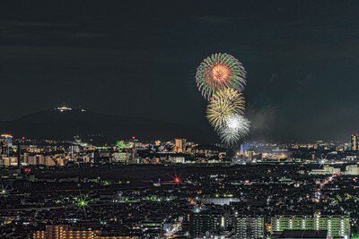 大阪の夜景を背景に打ち上がる大輪の花火