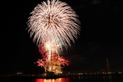 「色とりどりの花火が夜空と橋を照らす