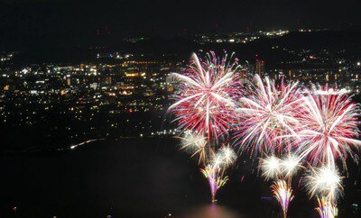 琵琶湖の夜景を背景に色鮮やかな花火が打ち上がる(イメージ)