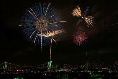 レインボーブリッジと東京湾の夜景を背景に咲き乱れる花火(前回開催時の様子)
