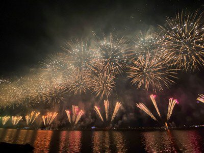 金色に輝く花火が川面を照らす瞬間