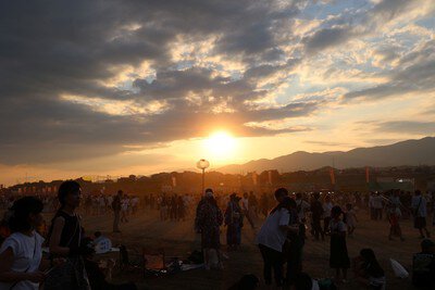 夕焼けに包まれ、にぎわい始める会場の様子