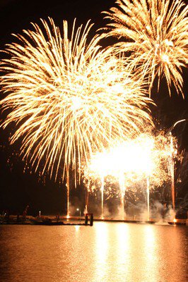 海面に映える黄金の花火が夜空を彩る