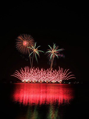 赤と緑が映える湖上花火の美しい競演