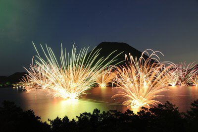 ボートから投げ込まれた水中花火が湖面に映る