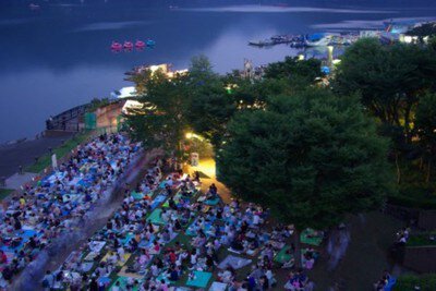 夕暮れの湖畔に集う多くの観客たち