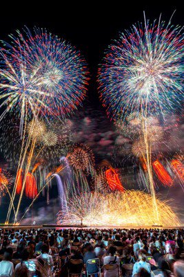 砂浜の観覧席を埋め尽くす来場者と海上花火