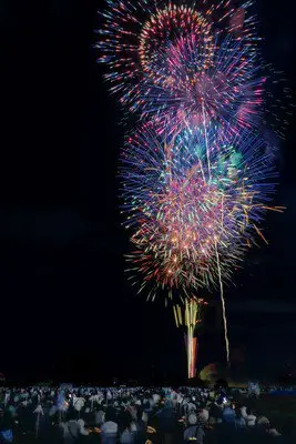 河川敷を埋め尽くす観客と夜空を彩る花火