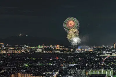 大阪の夜景を背景に打ち上がる大輪の花火