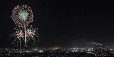 夜景とともに浮かぶ繊細な花火の輪